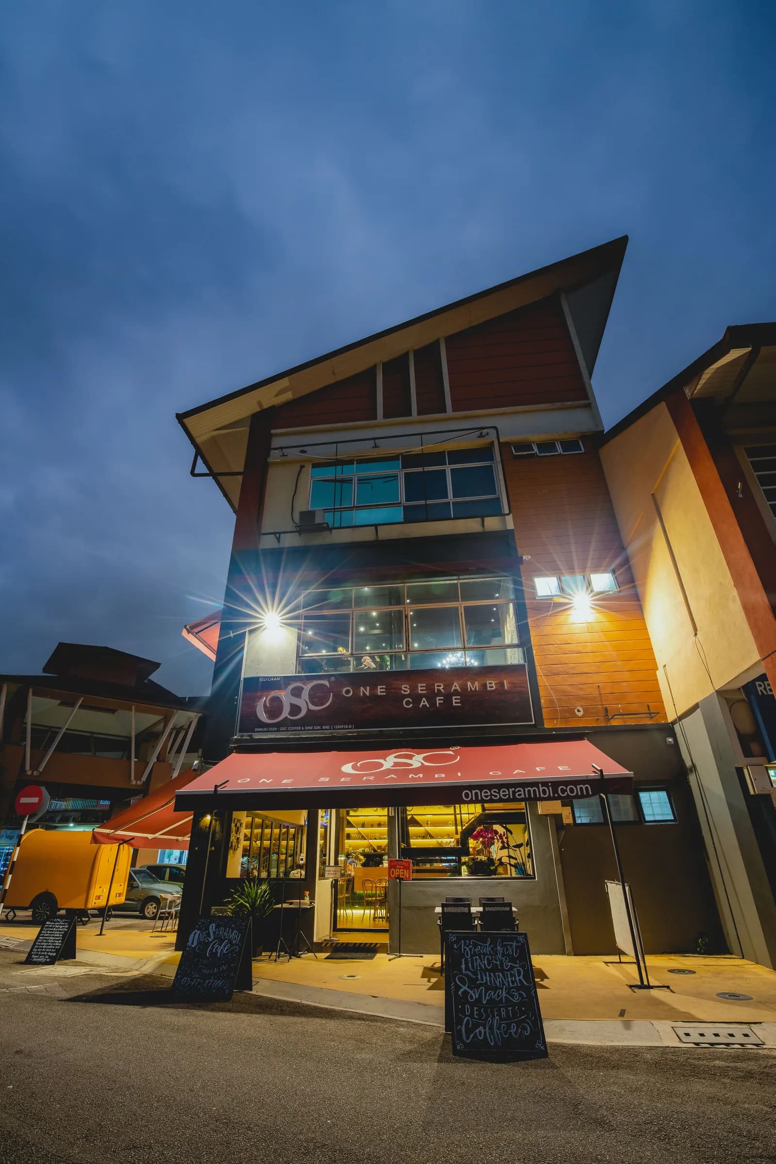 One Serambi Cafe exterior at twilight with modern architecture and lit storefront