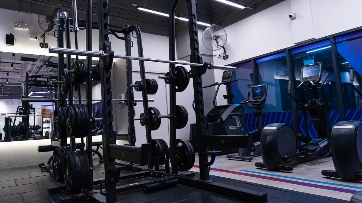 Gym interior with barbell rack, weights, and cardio machines