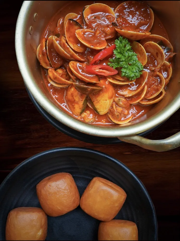 Sliced mushrooms in brown sauce with chili and cilantro; golden fried items in separate bowl