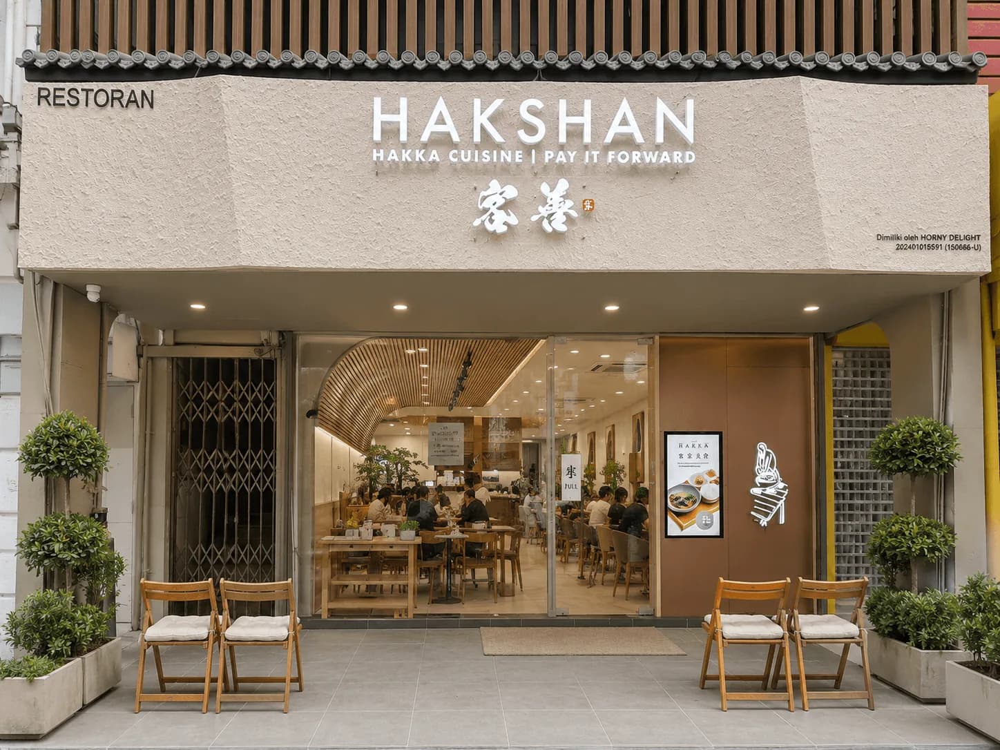 Hakshan restaurant storefront with warm lighting, dining area visible through glass, and outdoor seating