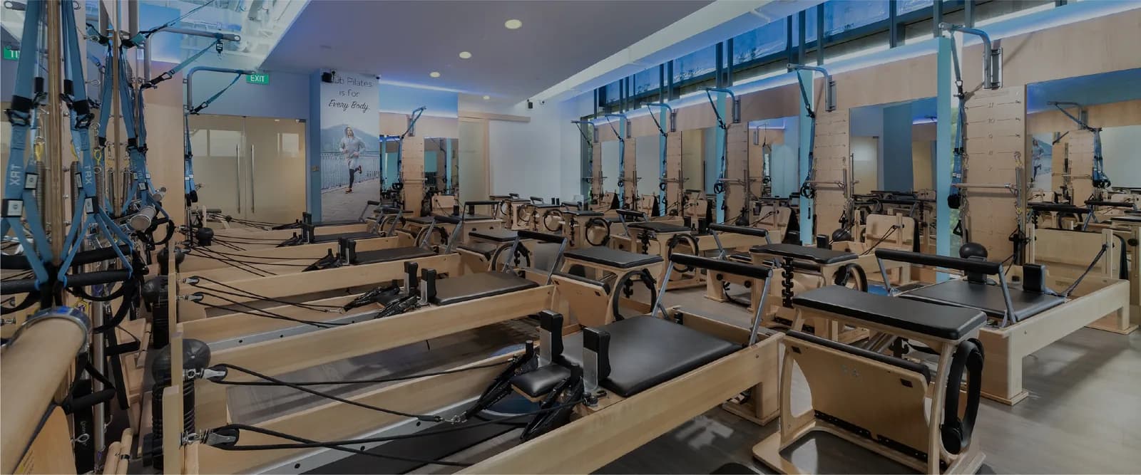 Pilates studio interior with multiple reformer machines and mirrored walls