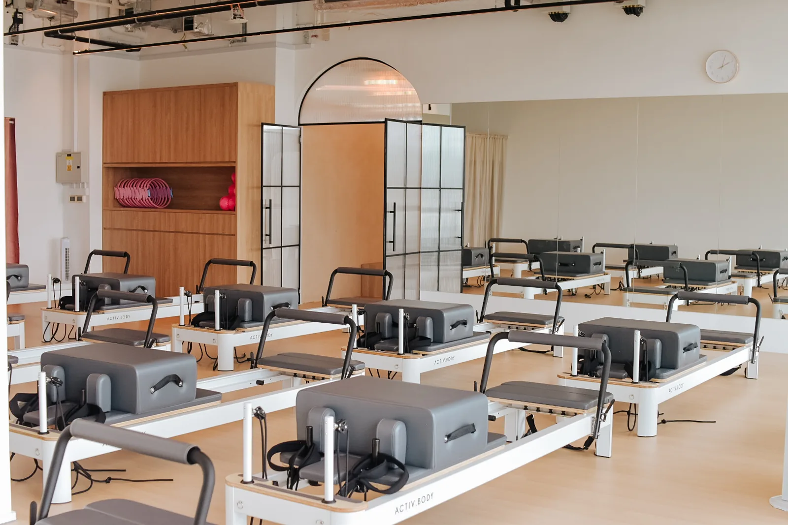 Pilates reformer studio with multiple machines arranged in rows and modern interior design