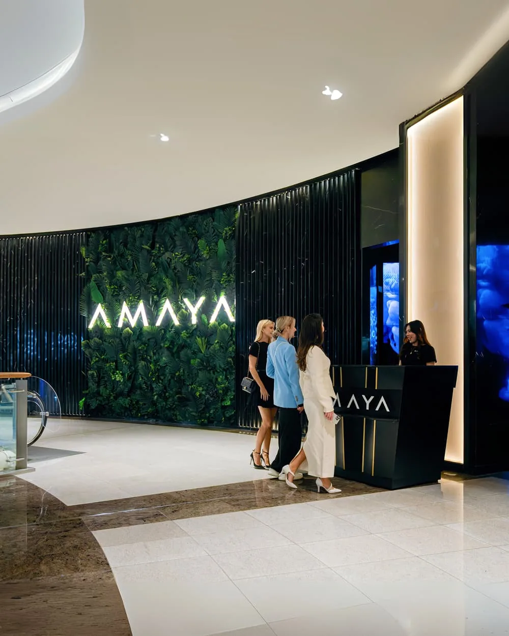Amaya shisha lounge reception with modern black and green design, staff at desk, customers entering