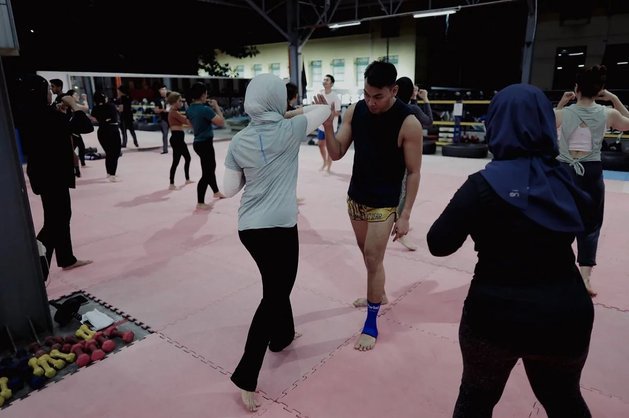 Boxers training and sparring on pink mat at indoor gym facility