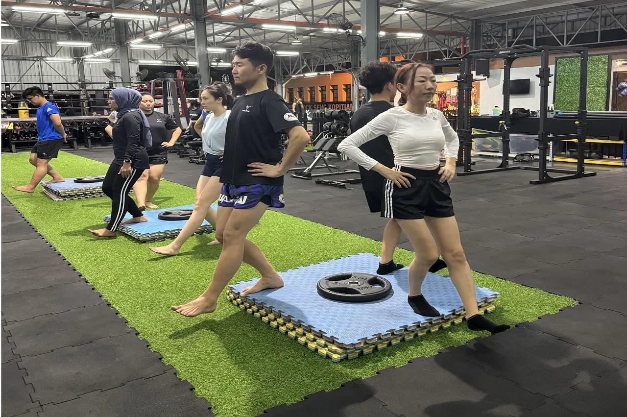 Group fitness class in progress at Ara Gym with participants on exercise mats in spacious facility