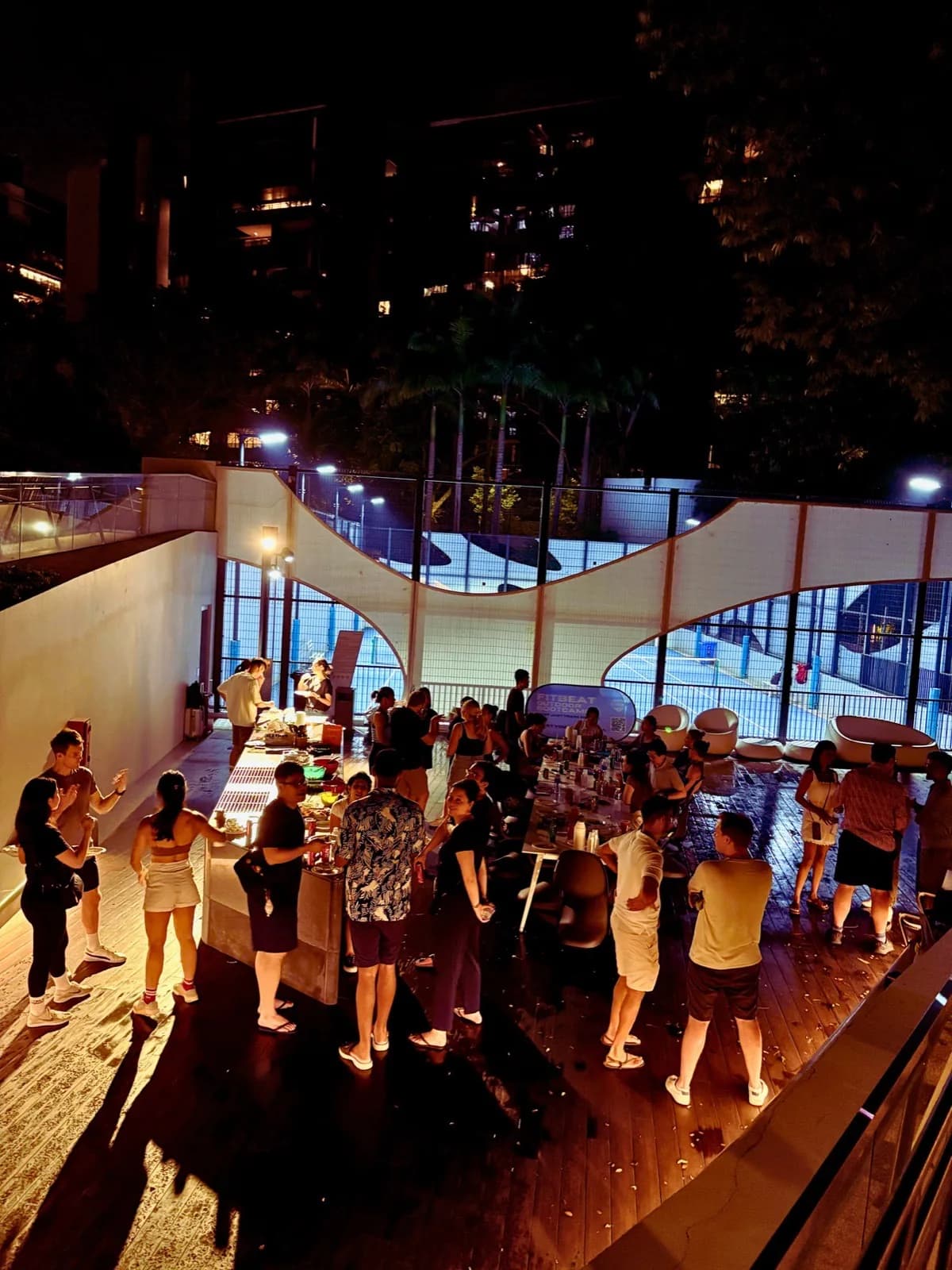 Group fitness event at rooftop venue with participants and city skyline at night
