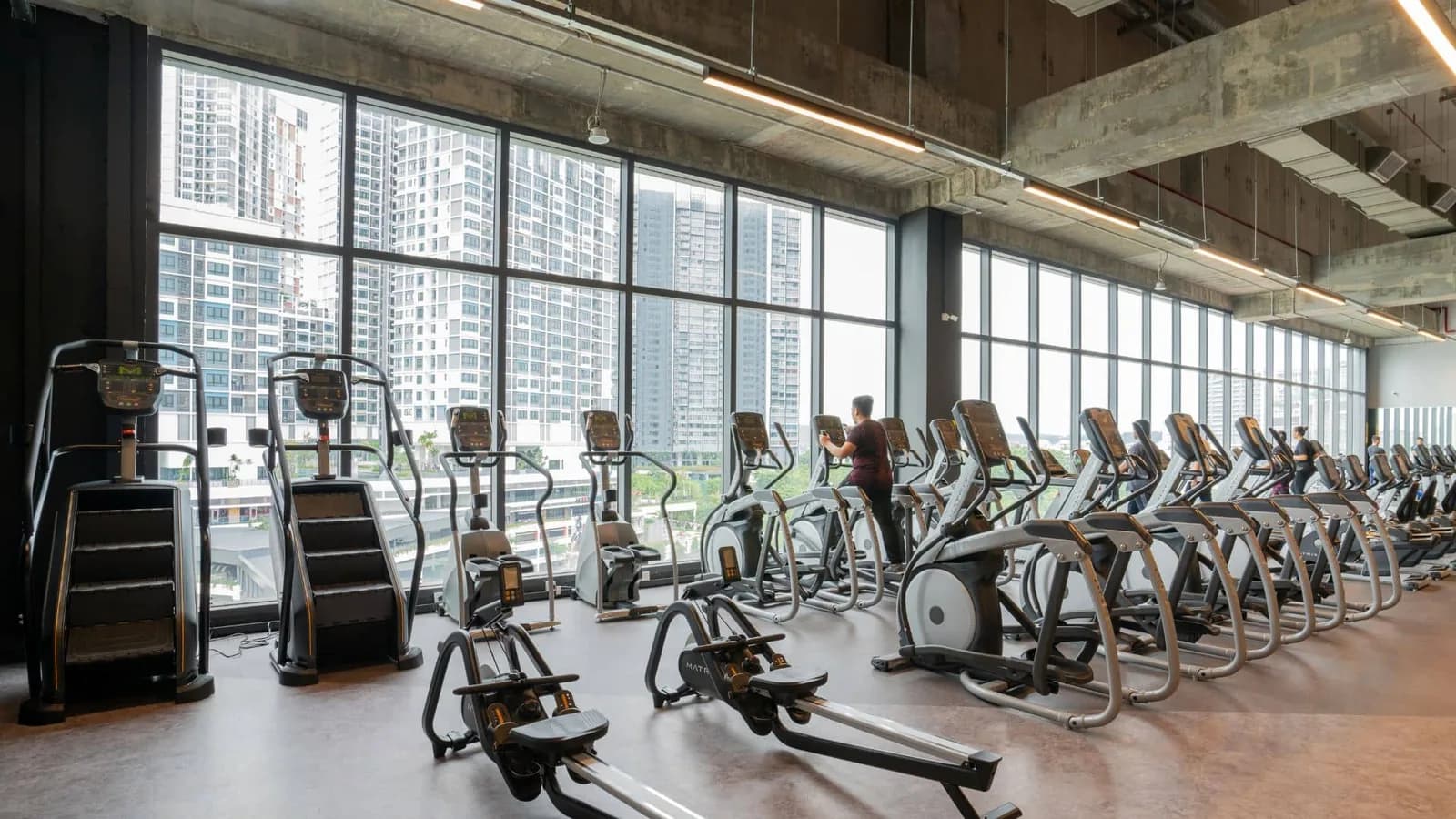 Gym cardio equipment area with city views from floor-to-ceiling windows