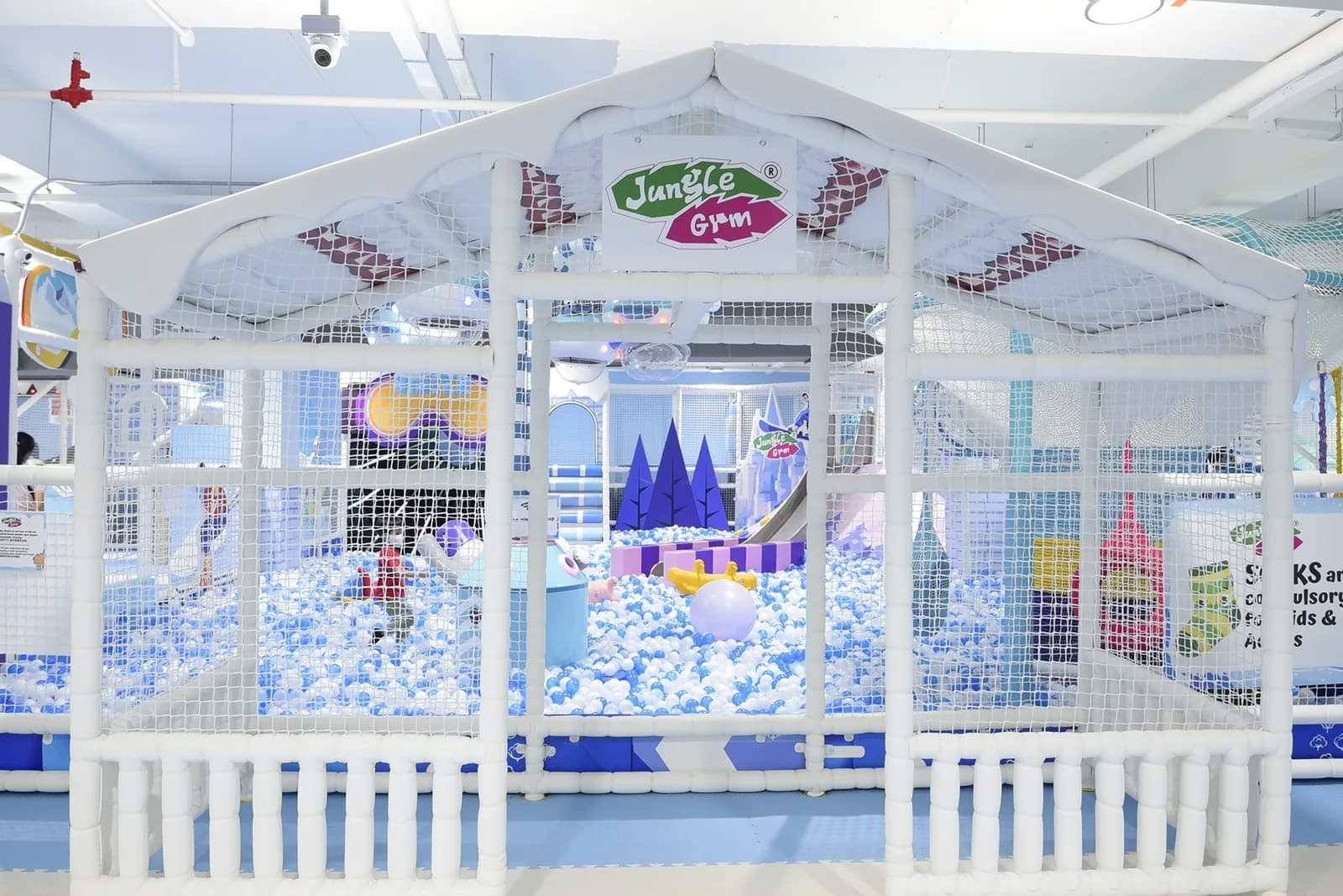 Indoor play facility with ball pit, castle structures, and netting designed for children's activities