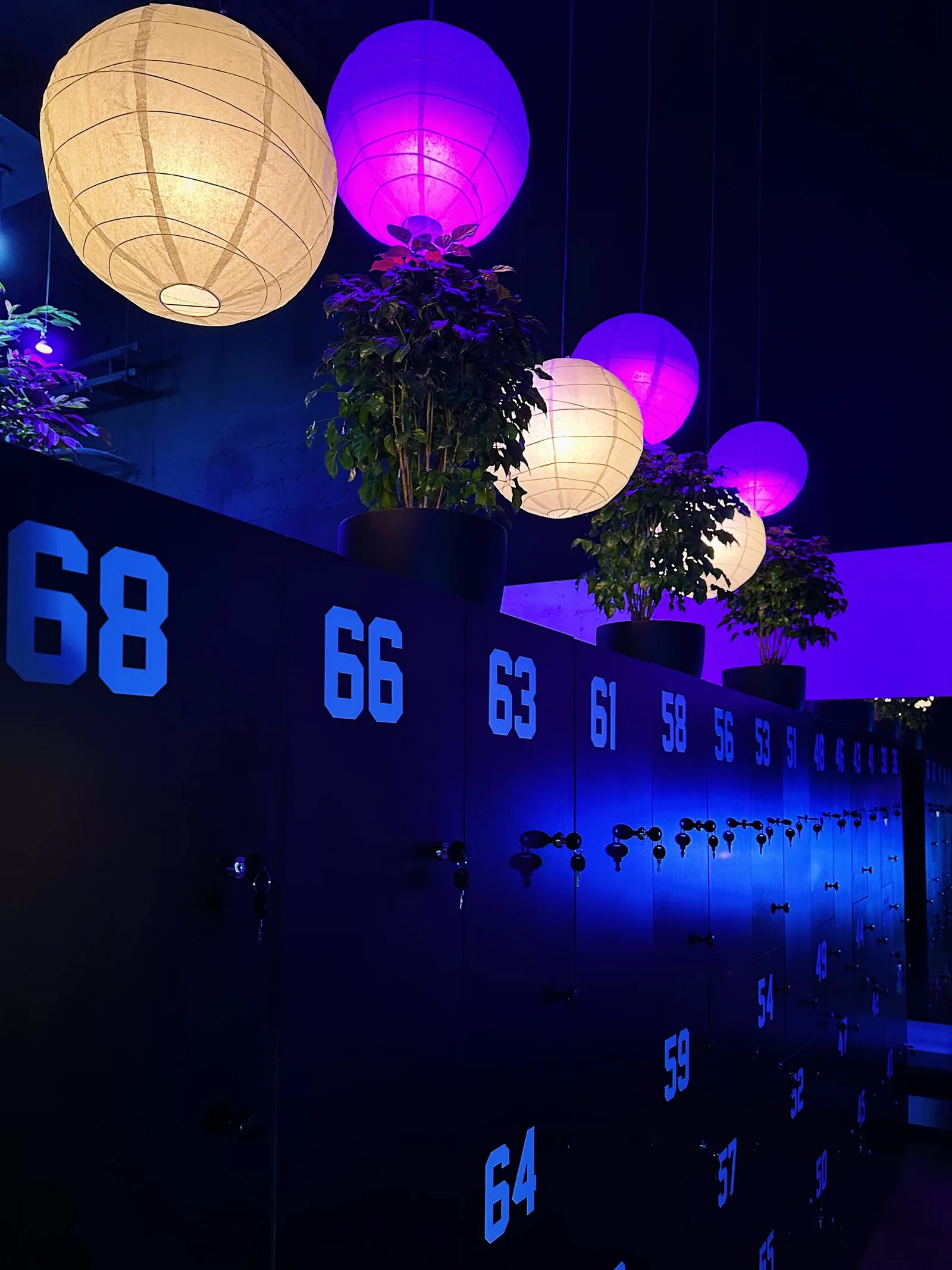 Stylish studio interior with glowing paper lanterns and numbered blue lockers