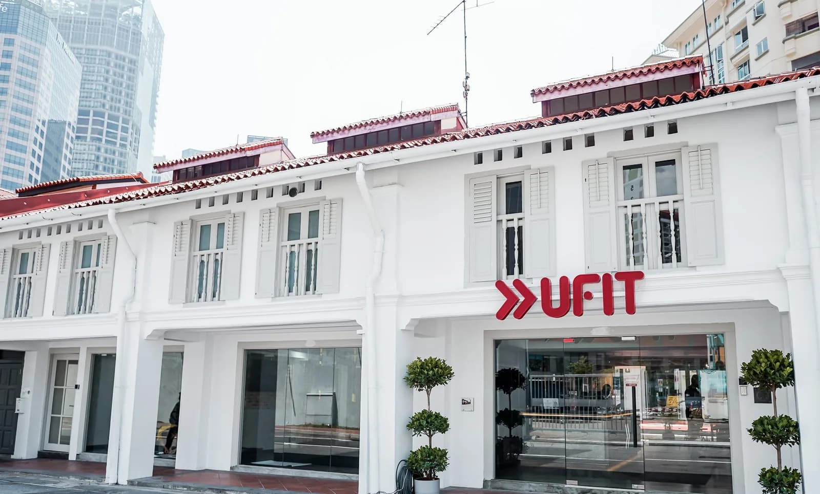 UFIT gym storefront in white heritage building with red roof and glass entrance doors