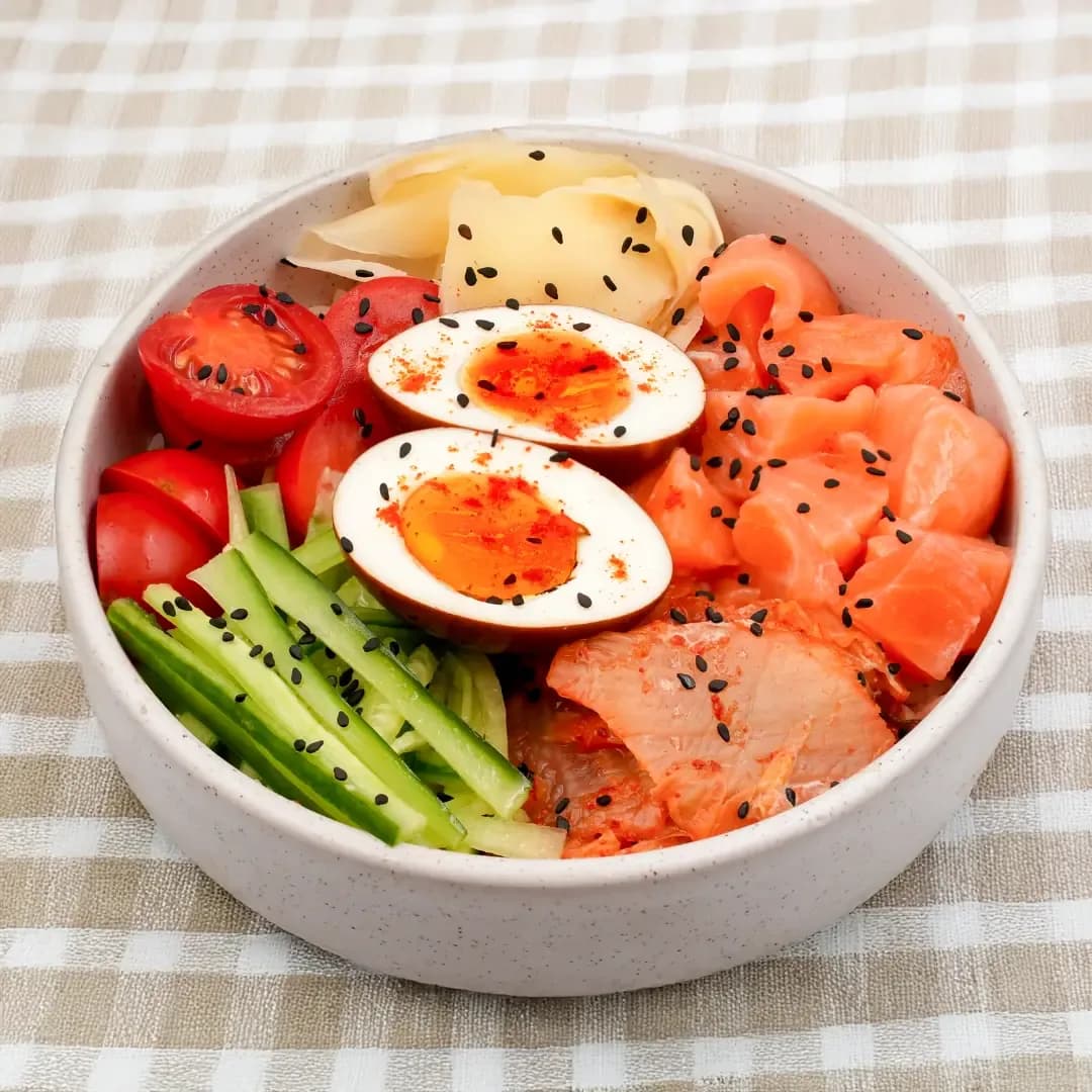 Breakfast bowl with eggs, salmon, fresh vegetables and sesame seeds