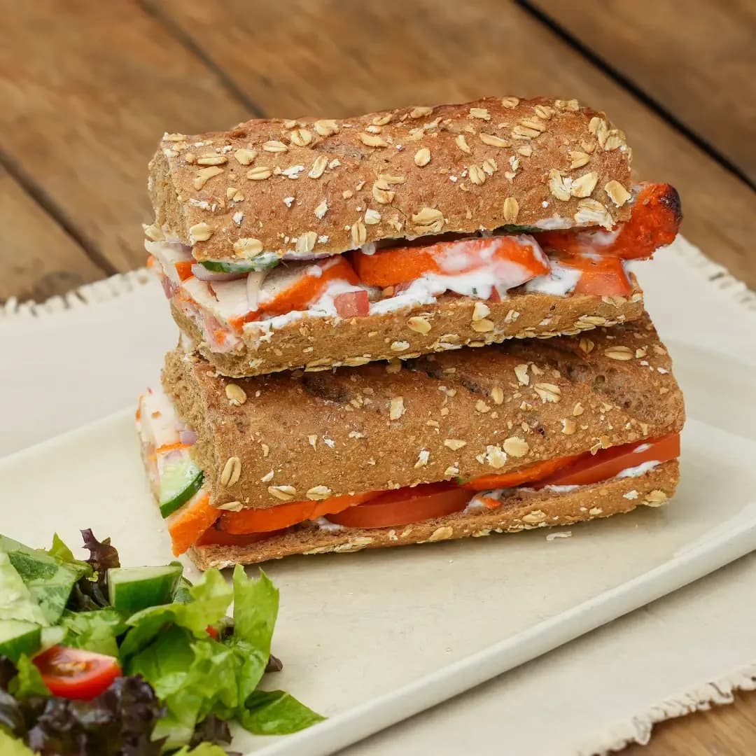 Smoked salmon and cream cheese sandwich on oat bread with fresh salad