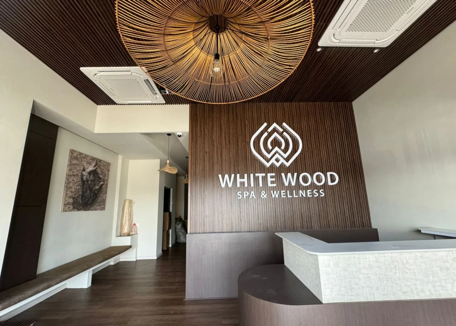 White Wood Spa reception area with modern design, wooden panels, and branded signage