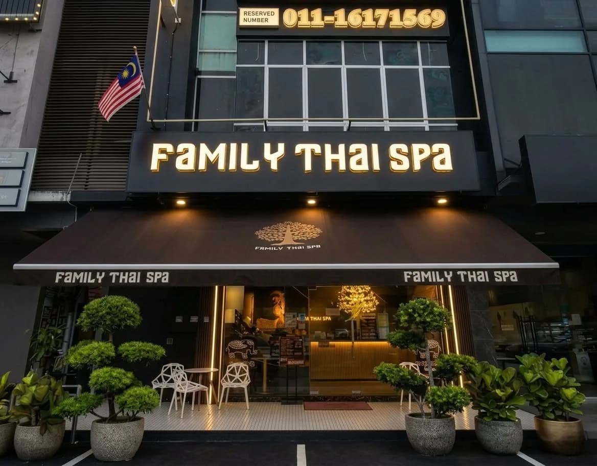 Family Thai Spa storefront with black awning, gold signage, potted plants, and illuminated entrance