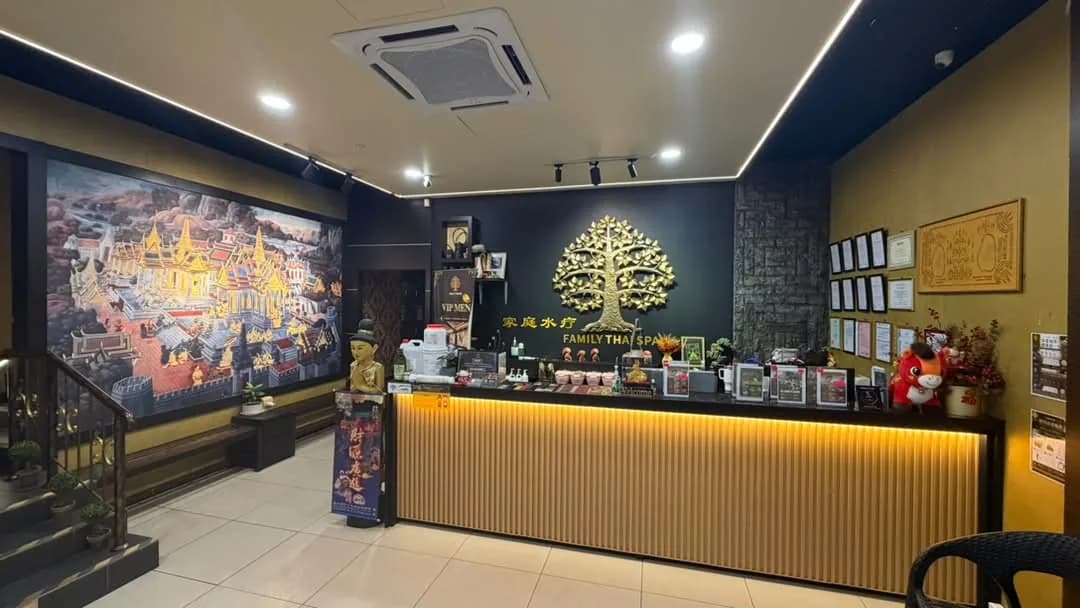 Modern spa reception desk with black and gold design, Thai artwork and decorative elements on walls