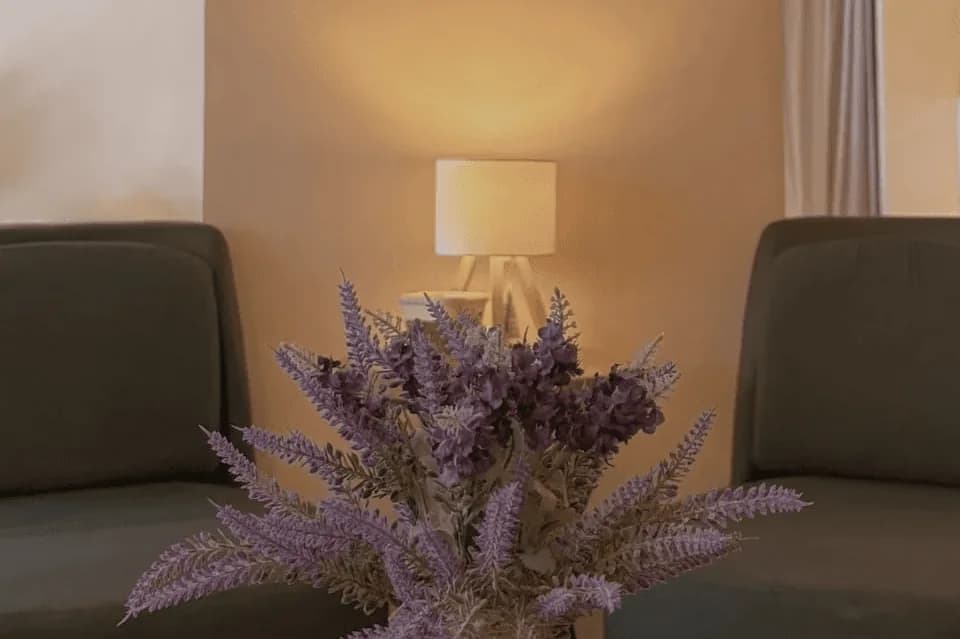 Spa relaxation area with comfortable seating, dried flower arrangement, and warm lighting