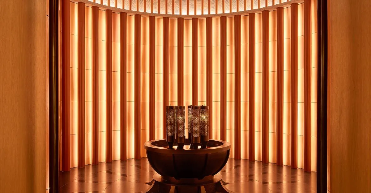 Spa interior with circular seating, warm lighting, and vertical wooden panel design
