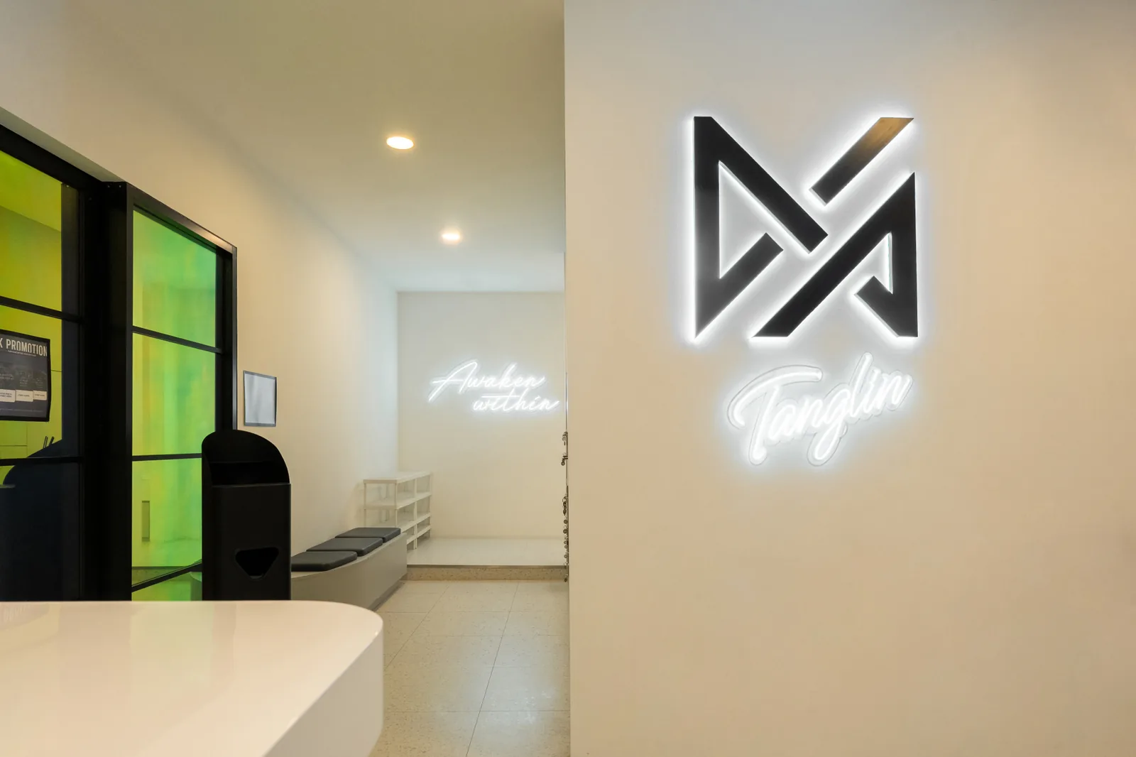 VAURA Pilates studio reception area with neon branding and modern minimalist design