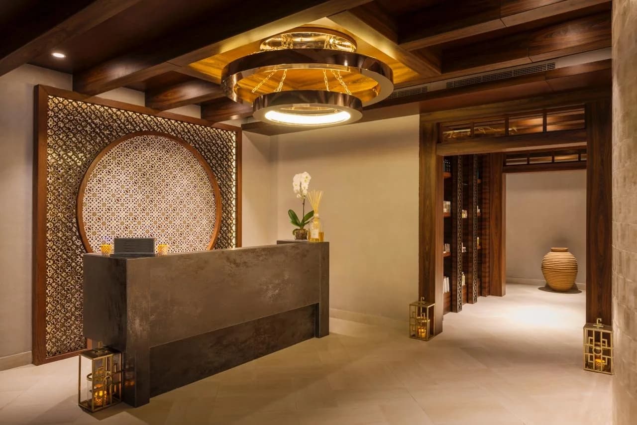 Luxe spa reception area with circular wall feature, modern chandelier, and upscale decor