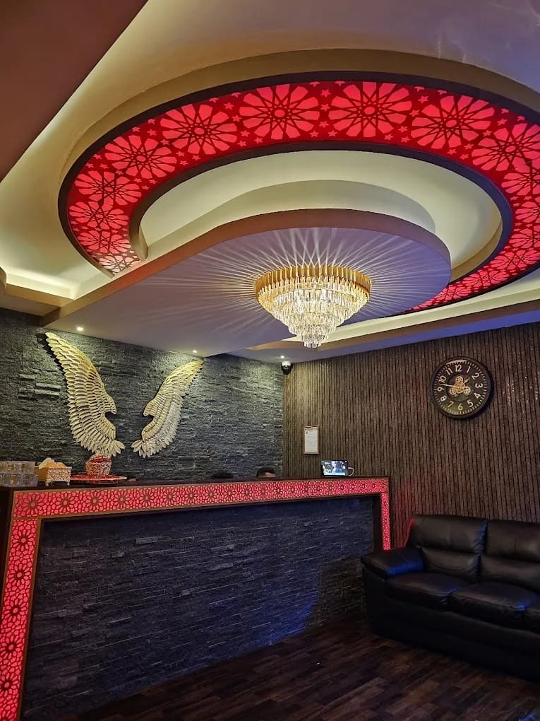 Elegant spa reception interior with illuminated red ceiling design and crystal chandelier