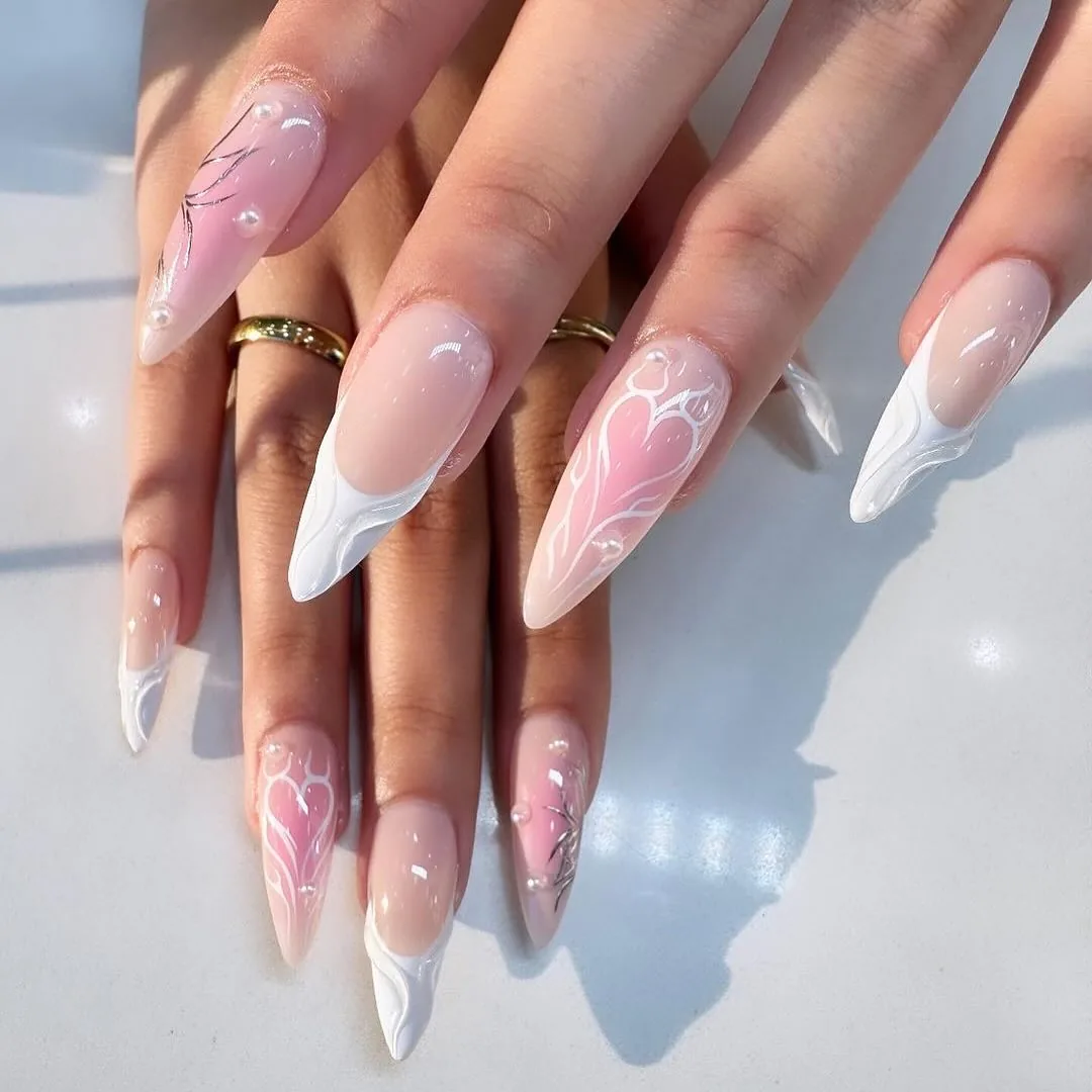 Almond nails with pink and white ombre gradient and hand-painted floral and heart designs