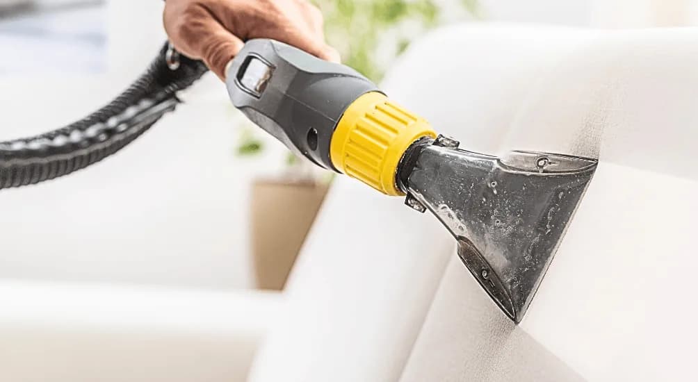 Professional steam cleaning equipment being used on a white surface during a cleaning job.