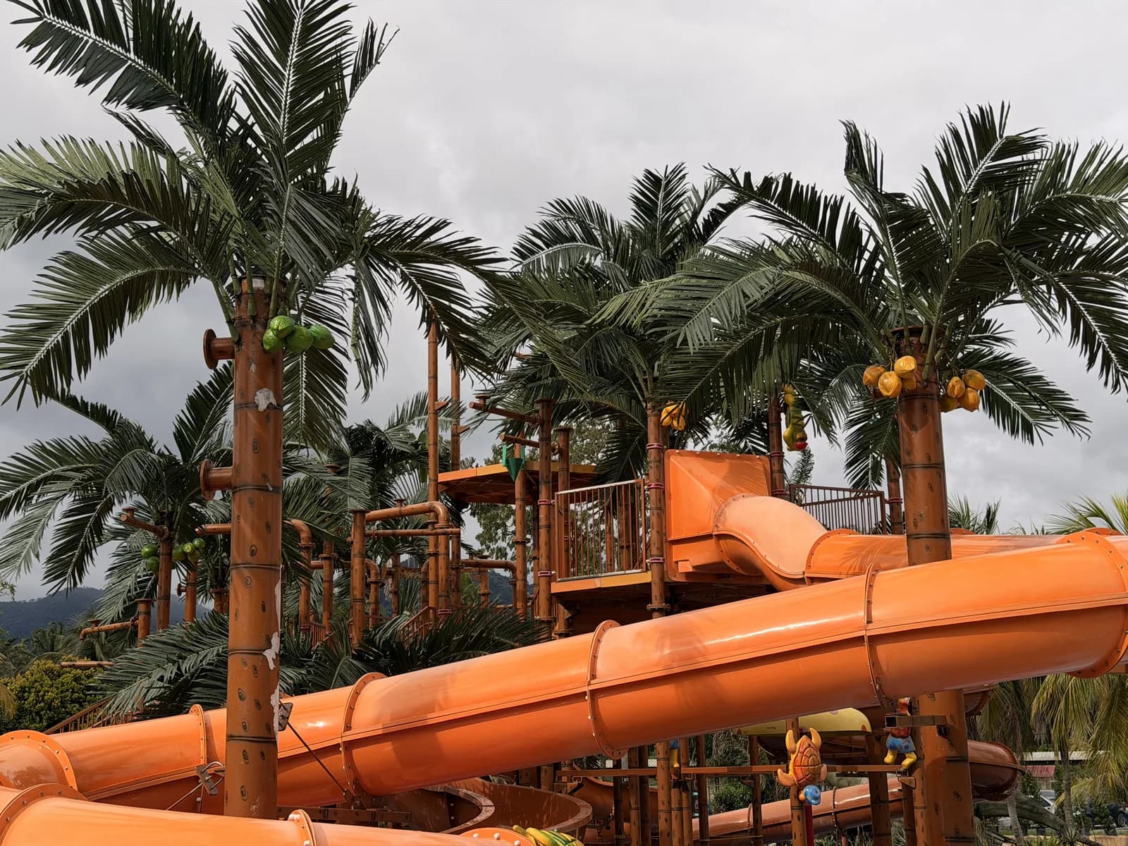 Orange water slides with palm trees at a tropical water park
