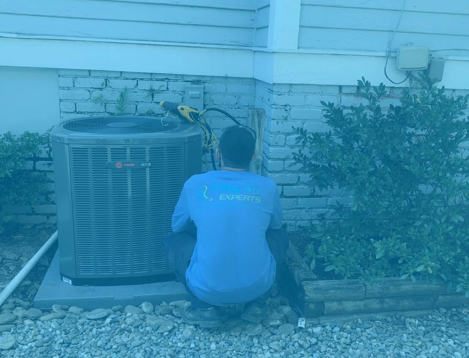 HVAC technician servicing outdoor air conditioning unit