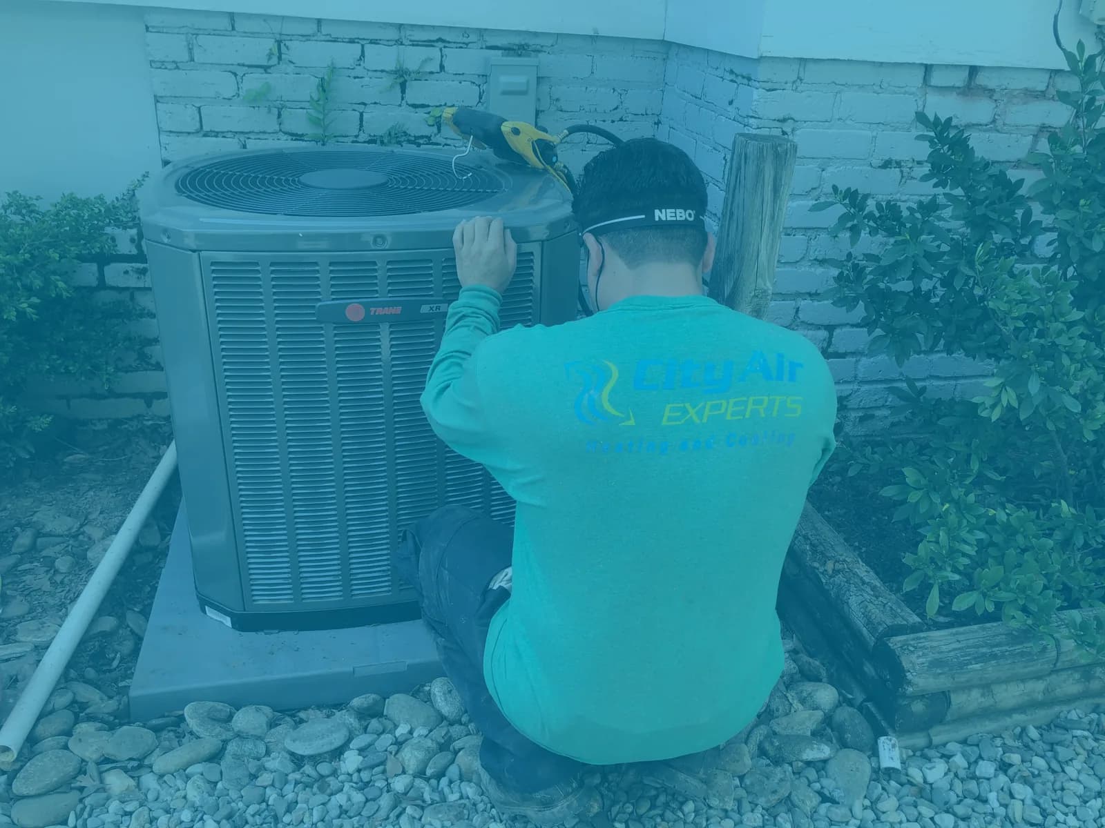 Technician servicing an AC unit on a residential outdoor pad