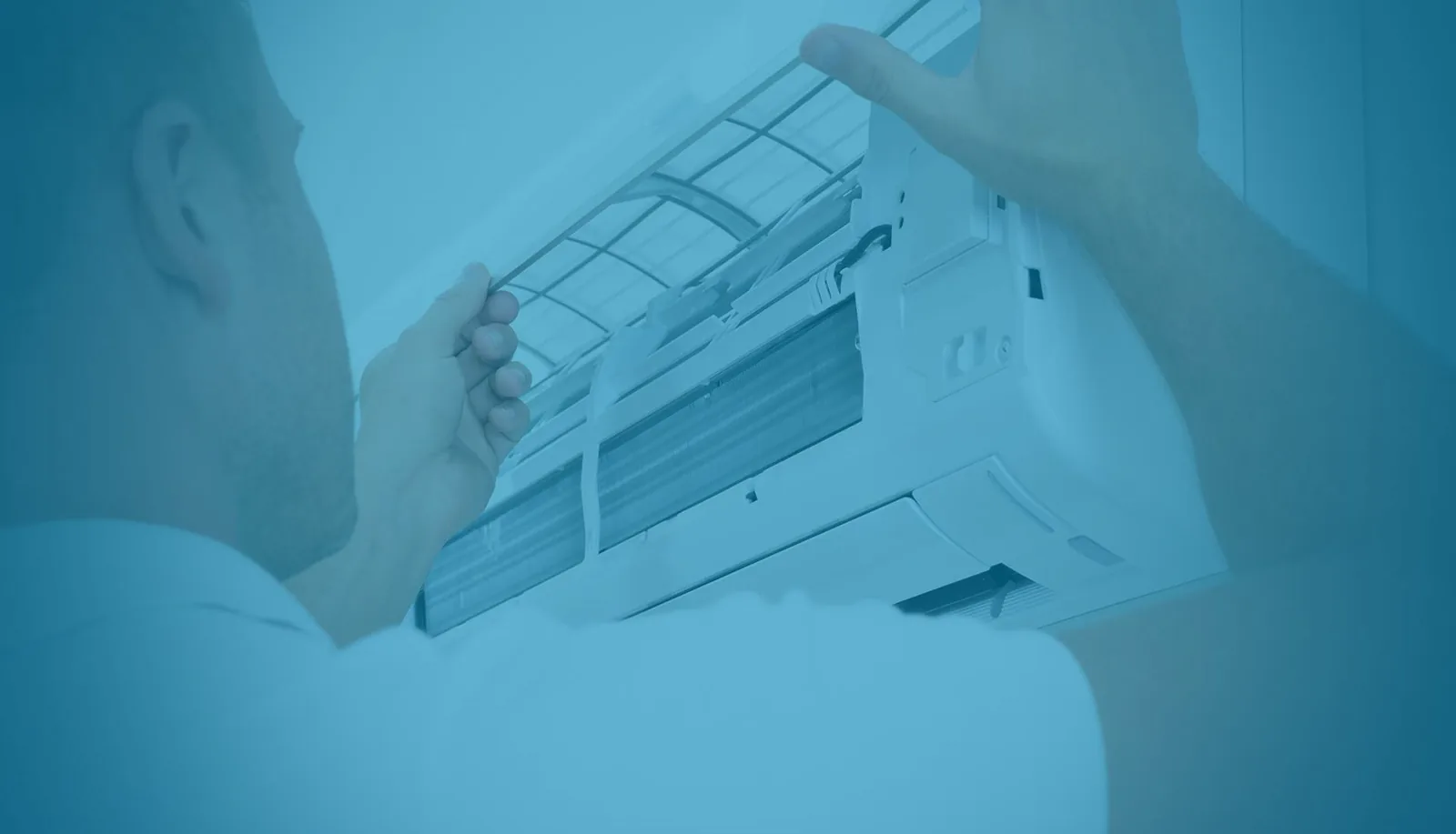 Technician removing filter from air conditioning unit during service