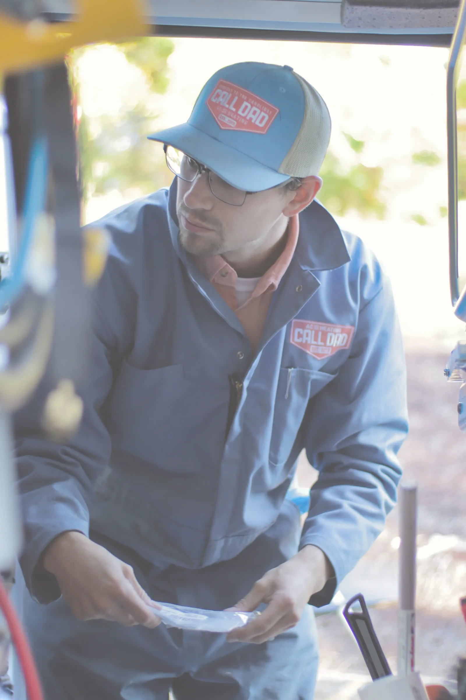 HVAC technician in Call Dad uniform working on air conditioning equipment