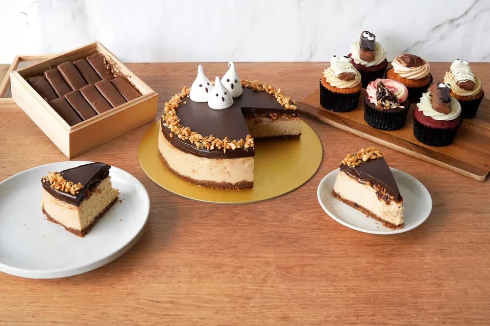 Assorted chocolate cakes, cupcakes, and chocolate truffles displayed on wooden table
