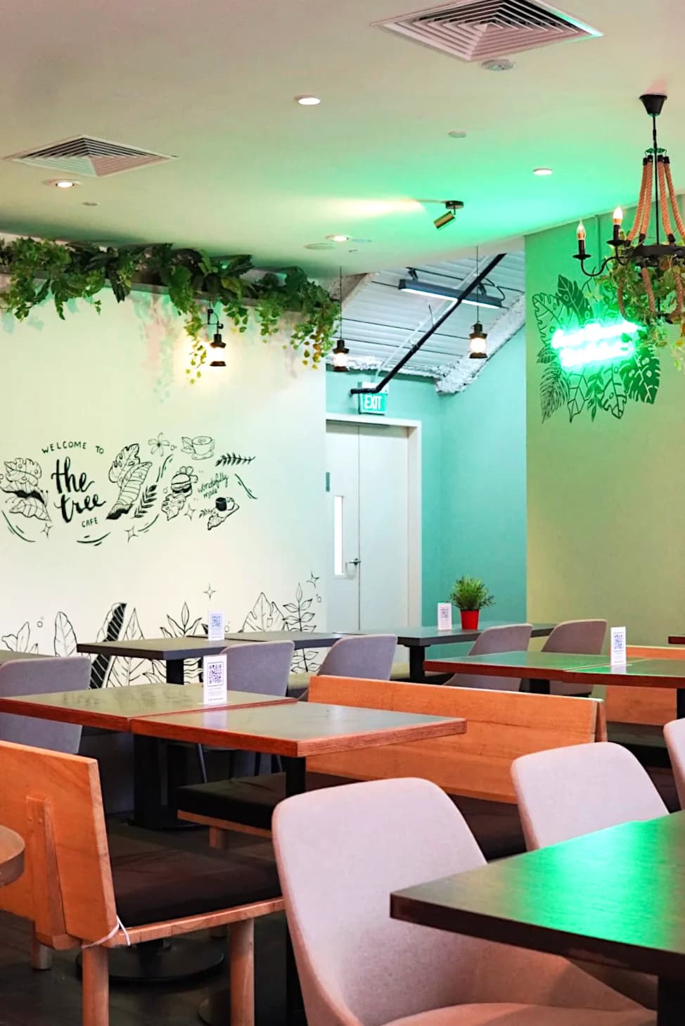 Cafe interior with colorful walls, plants, pendant lights, and modern seating arrangements
