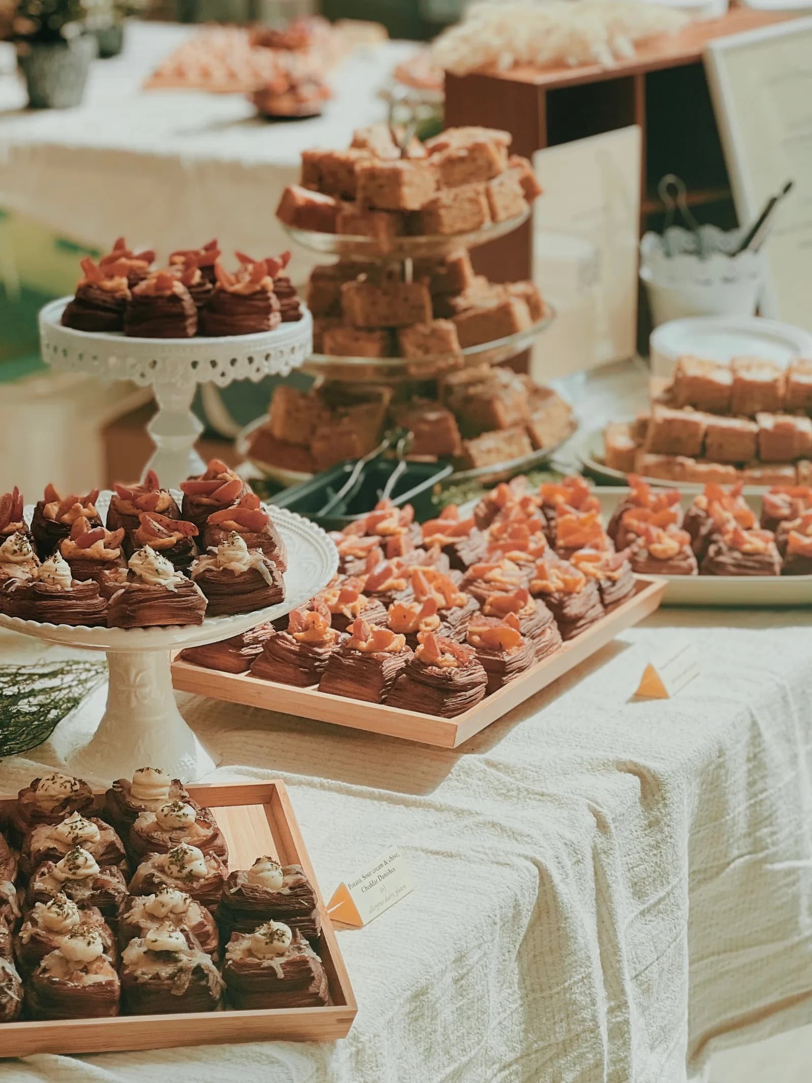 Chocolate pastries and cakes displayed on pedestals and boards at a bakery café.