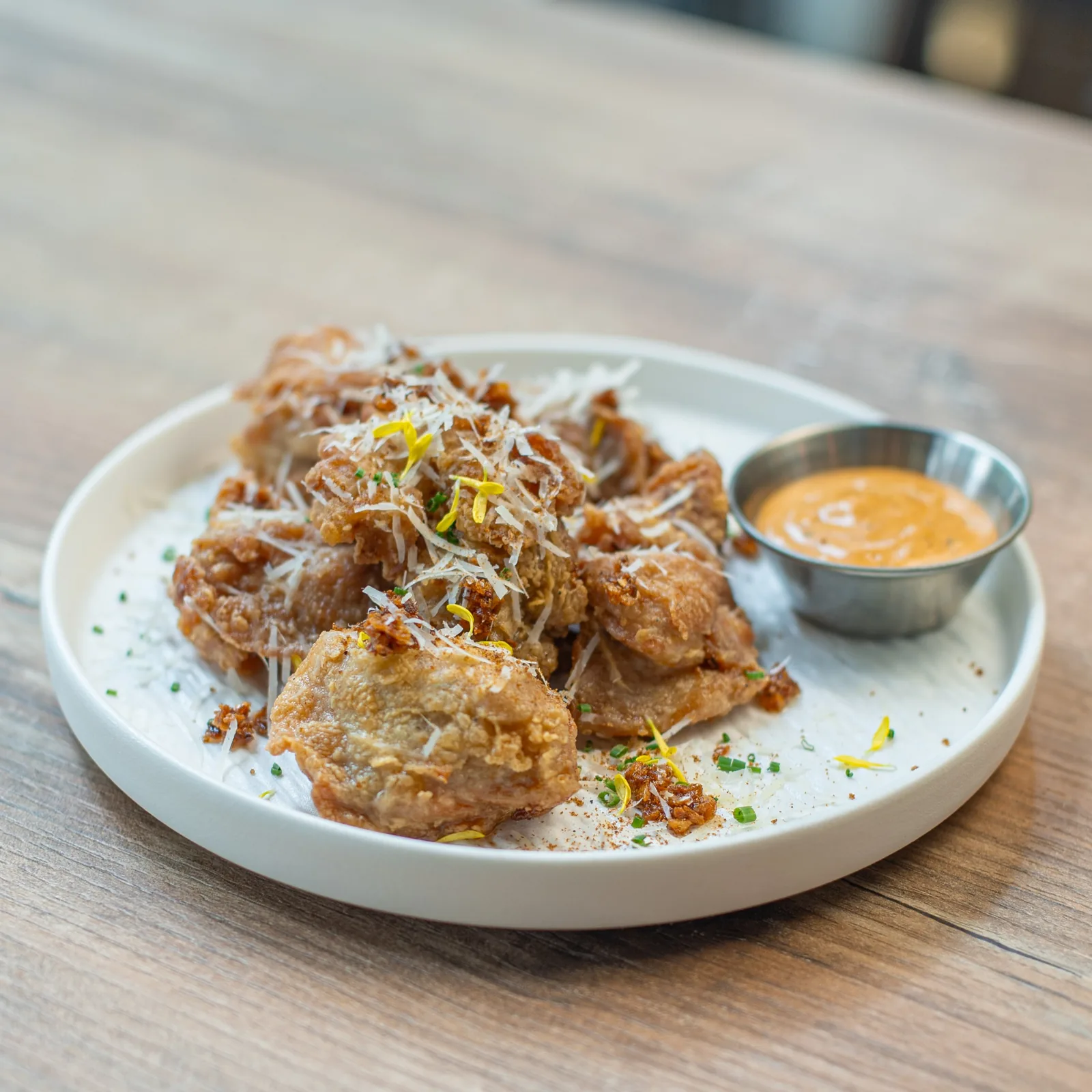 Crispy fried fritters with coconut and citrus garnish, served with sauce