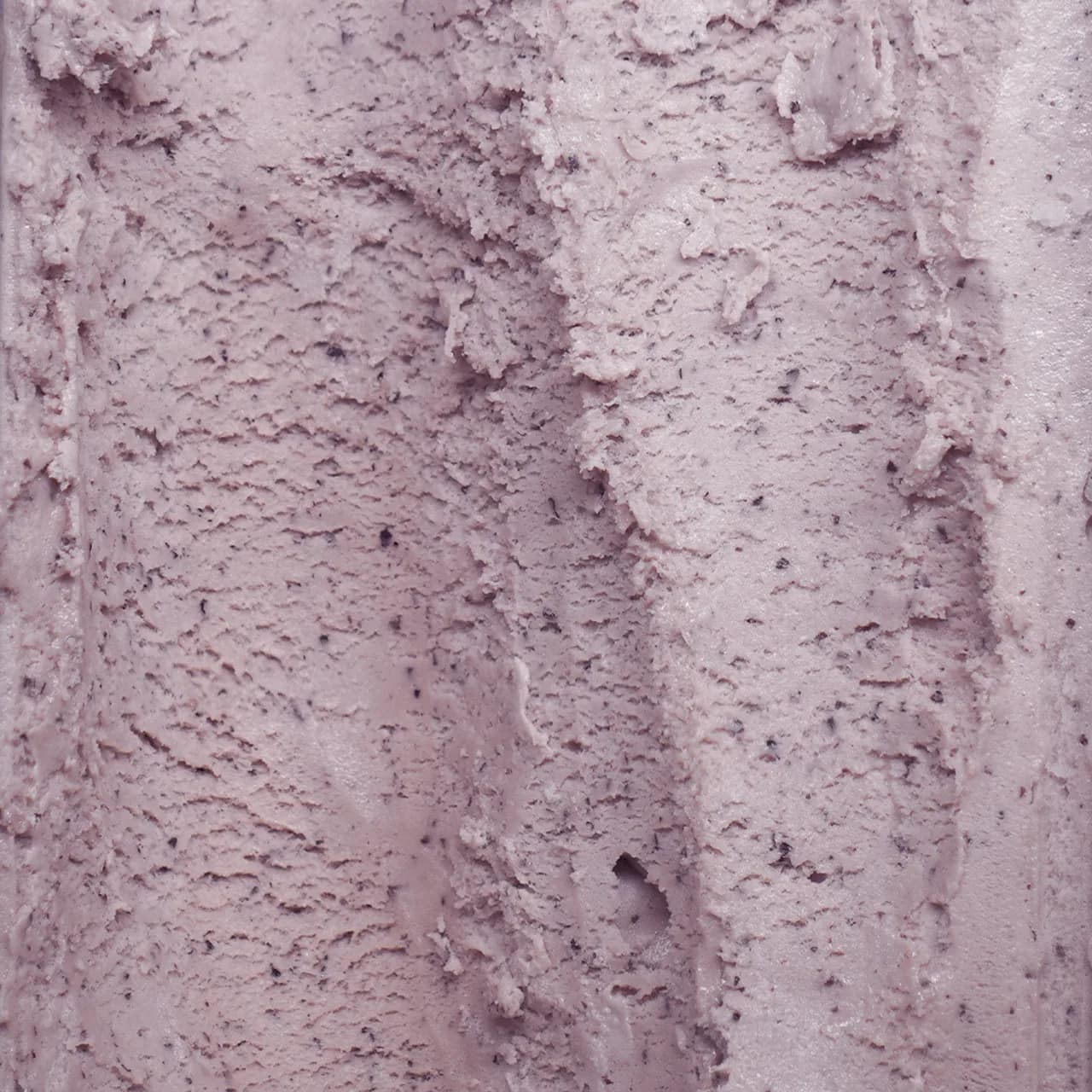 Pink berry ice cream with visible texture and fruit pieces
