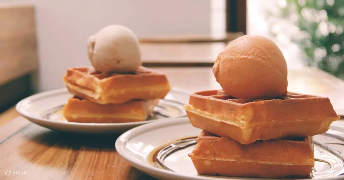 Plated waffle desserts topped with ice cream scoops on white plates
