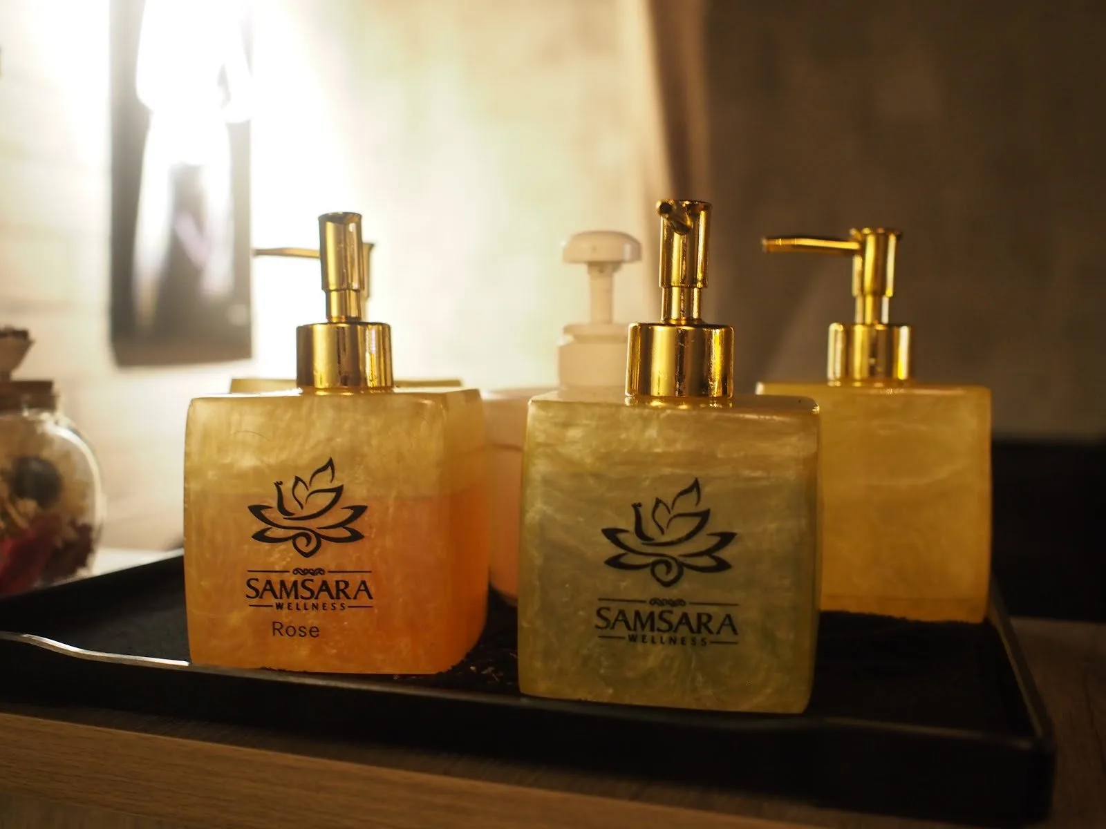 Samsara Wellness branded product dispensers with gold pumps on display tray