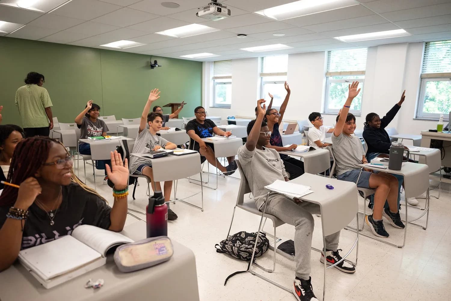 Students in a test prep classroom with raised hands during an interactive lesson