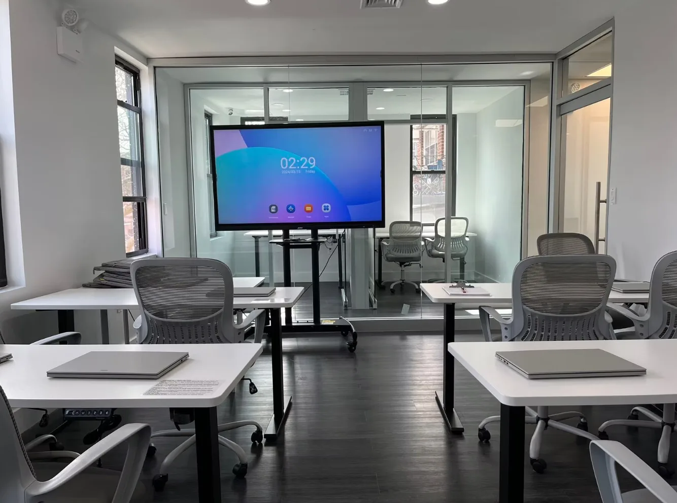 Professional tutoring center meeting room with tables, chairs, and presentation screen