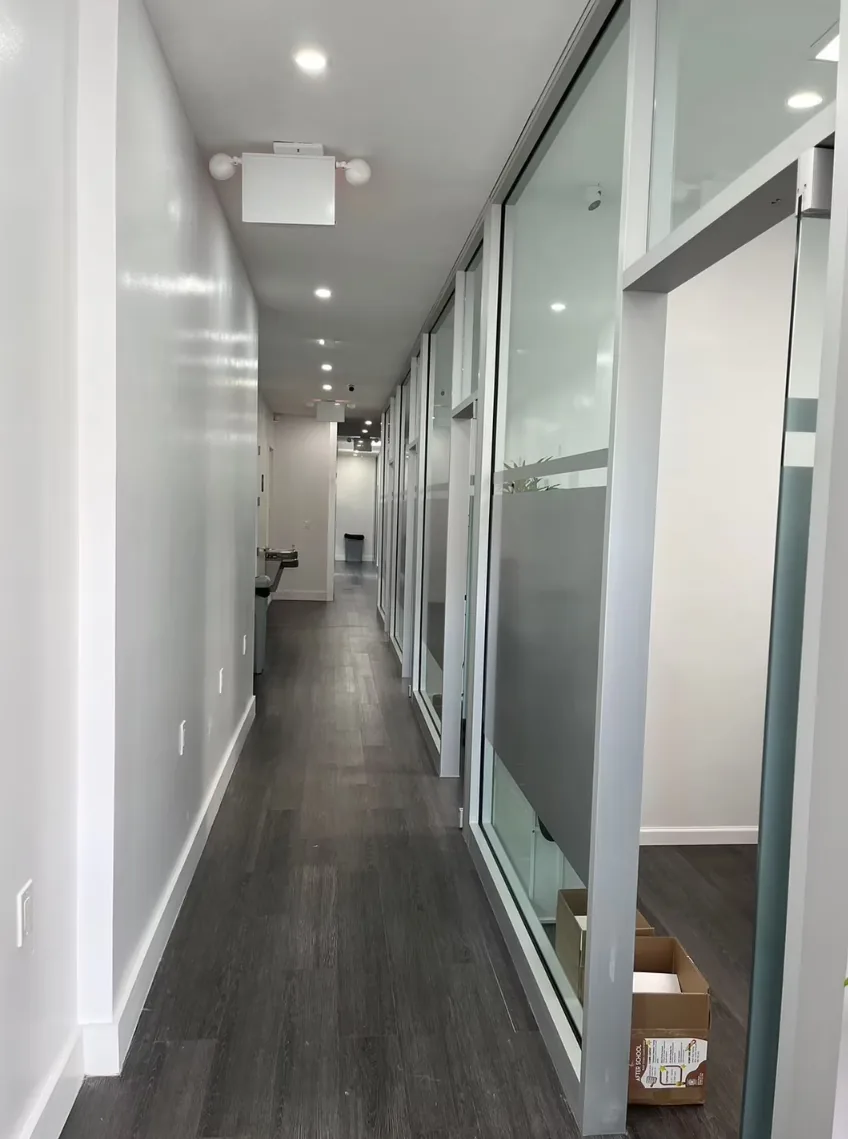 Clean hallway with glass-walled tutoring rooms and recessed lighting