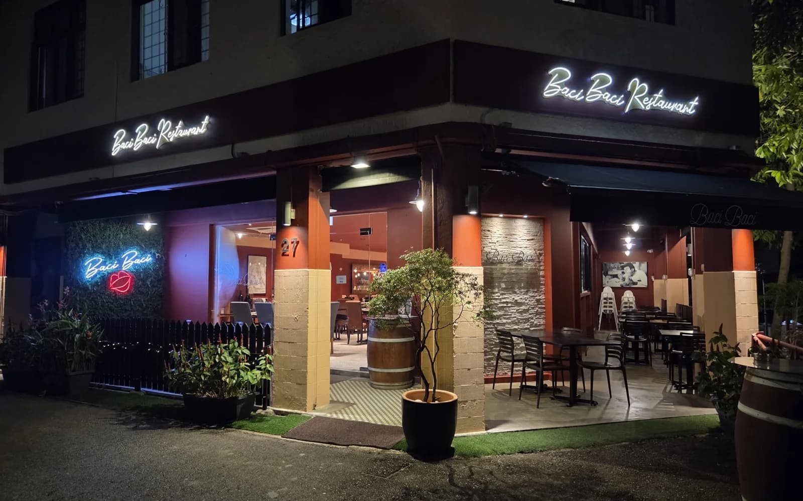 Baci Baci Ristorante Italiano storefront at night with neon sign and open dining area