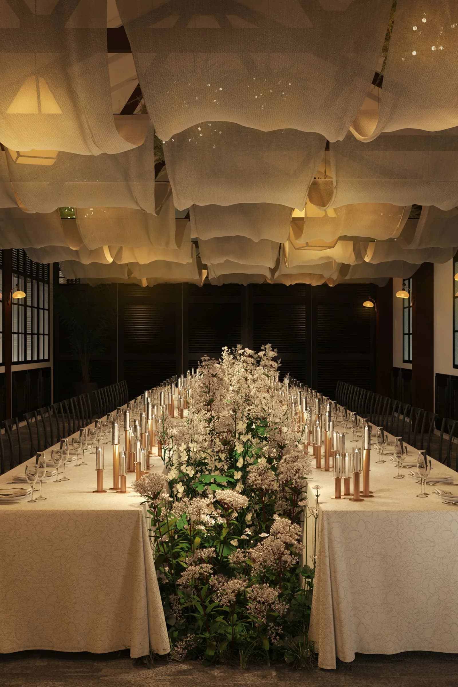 Wedding banquet hall with long dining table, white flowers, candles, and sculptural ceiling lights