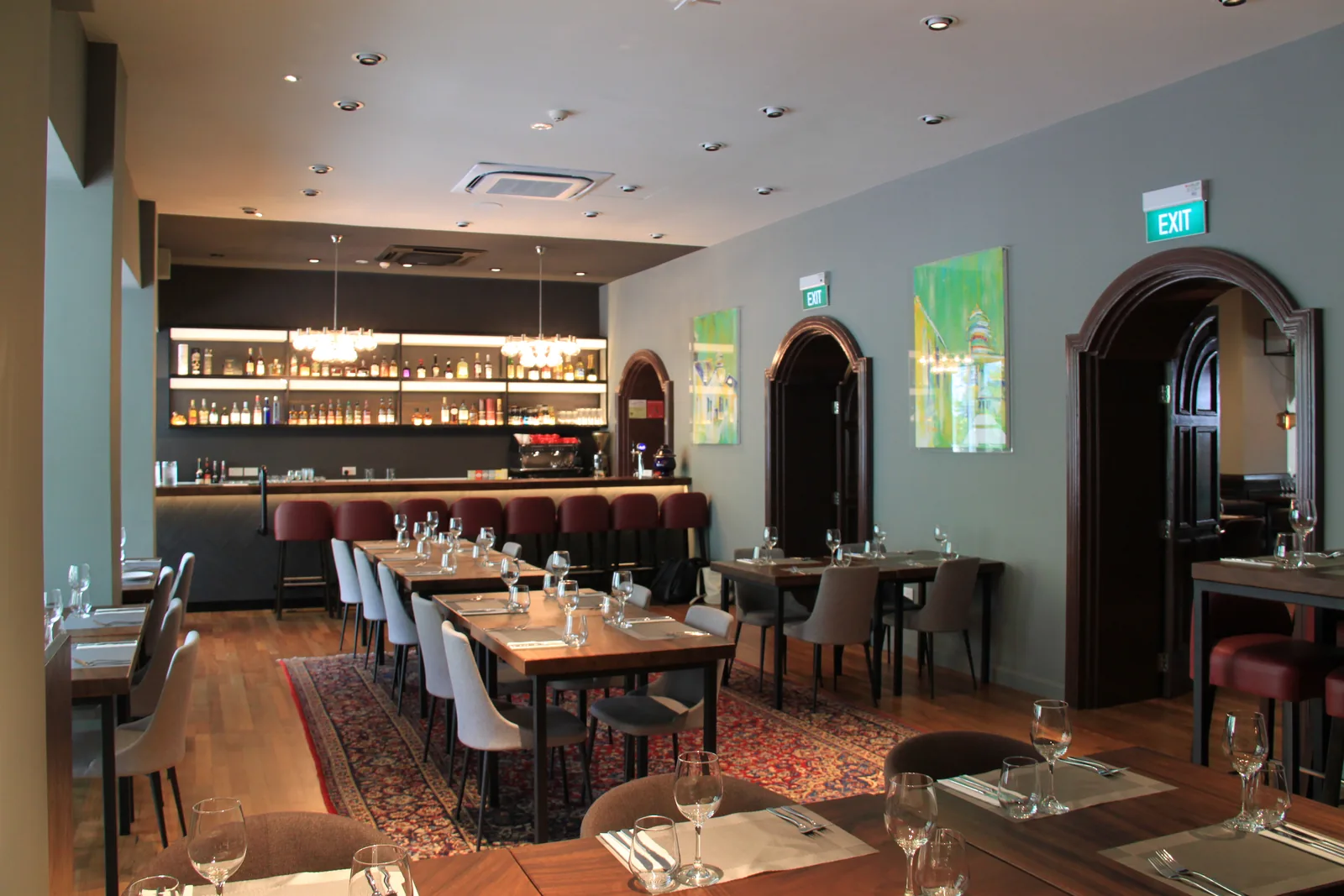 Elegant restaurant dining room with bar counter, wooden tables, and contemporary interior design