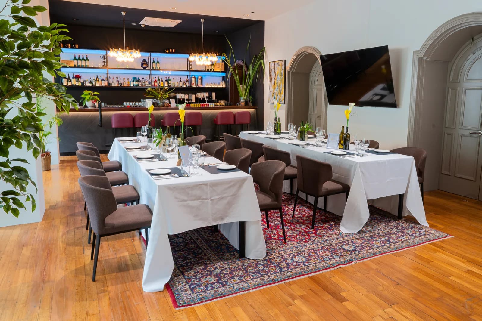 Upscale private dining room with set tables, bar counter, and elegant decor
