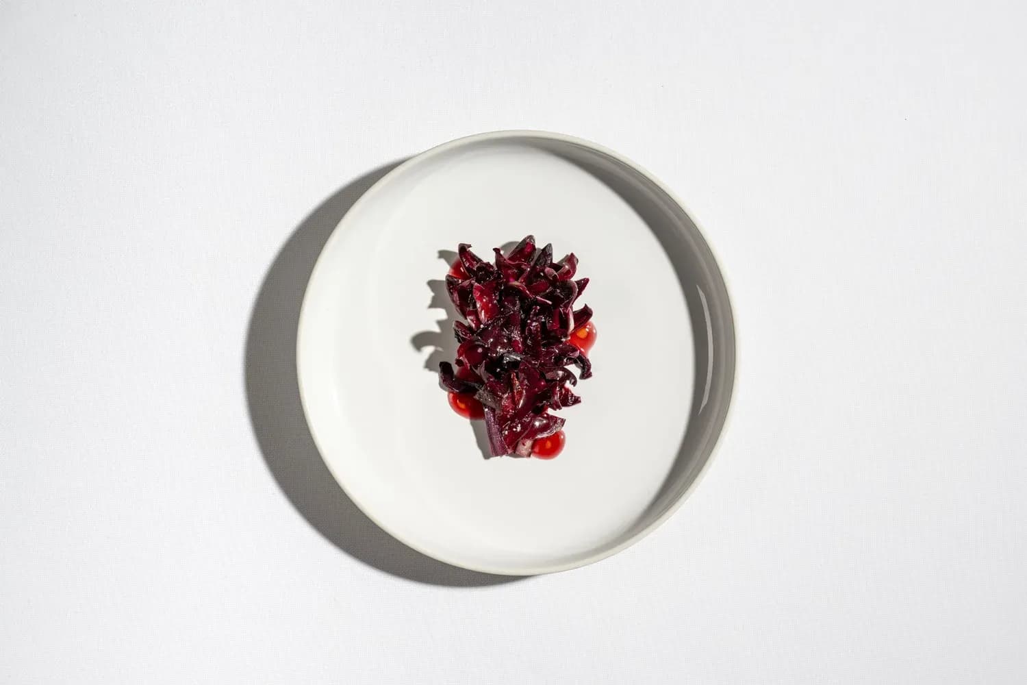 Julienned beetroot arranged in center of white plate with subtle shadows