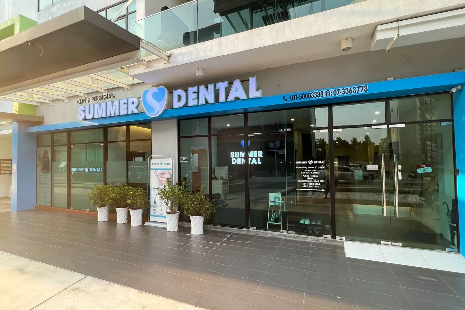 Summer Dental Clinic storefront with blue signage and glass entrance doors
