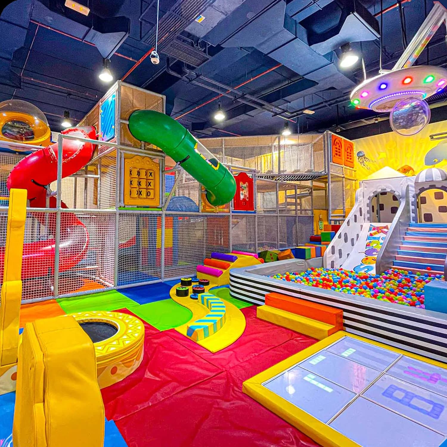 Vibrant children's play center with slides, ball pit, climbing structures and colorful themed play zones