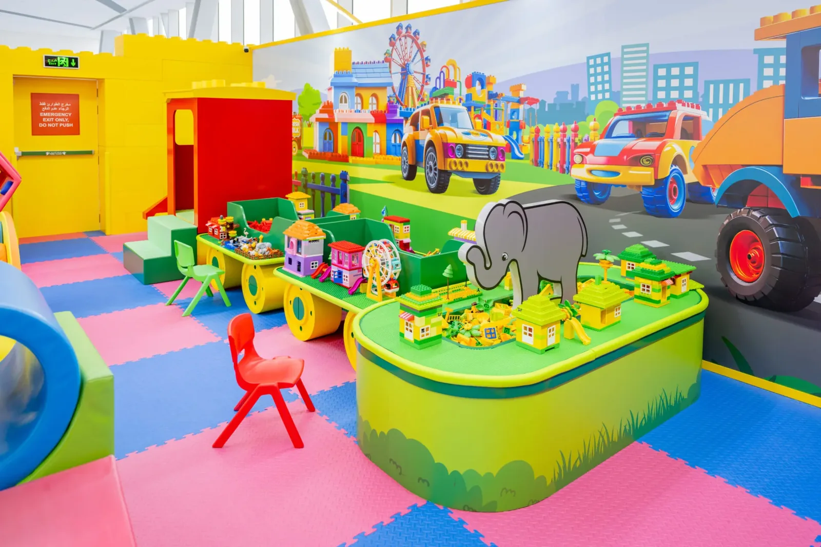 Colorful indoor play center with toy vehicles, play structures, and activity stations for children