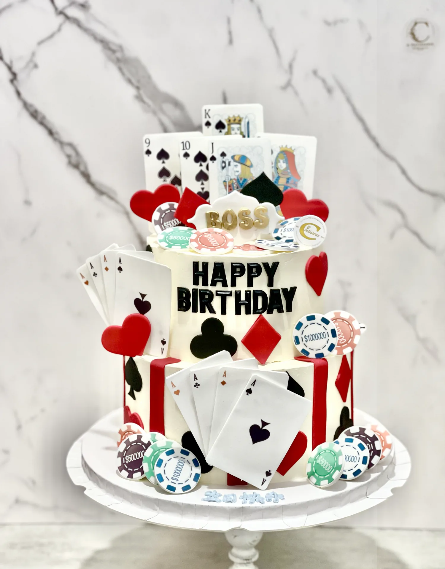 Multi-tier casino-themed birthday cake with playing cards, poker chips, and red heart decorations
